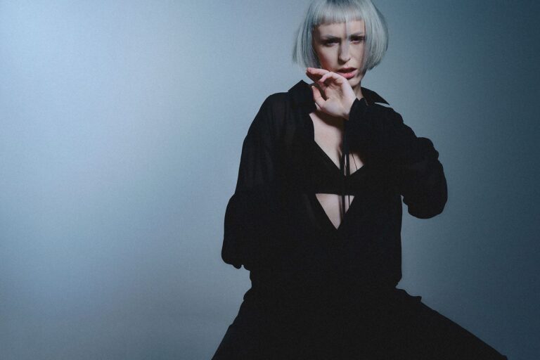 Model mit grauem Haar vor blauem Farbverlauf im Fotostudio