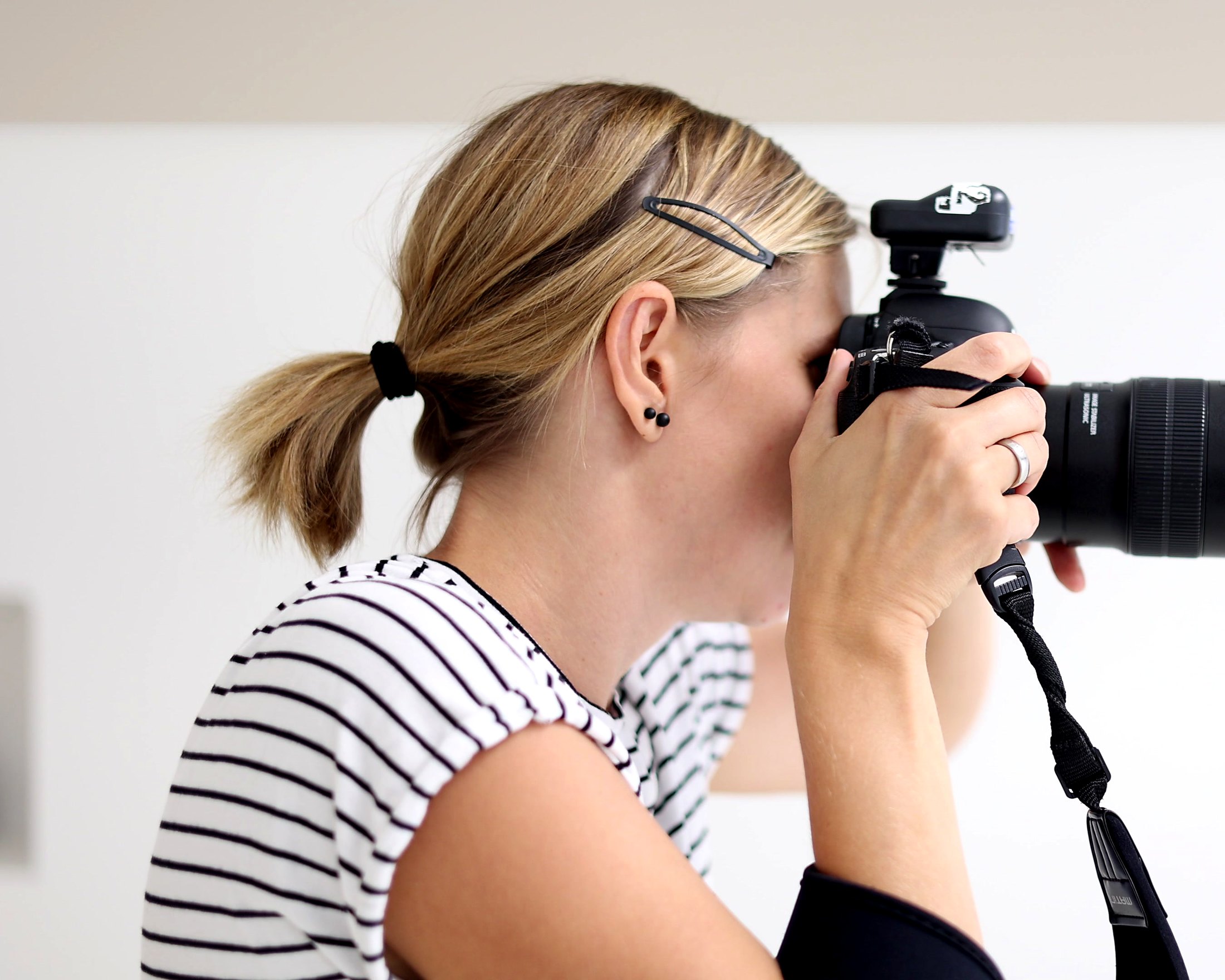 Fotografin mit Kamera und Blitzauslu00f6ser bei einem Shooting im studio242