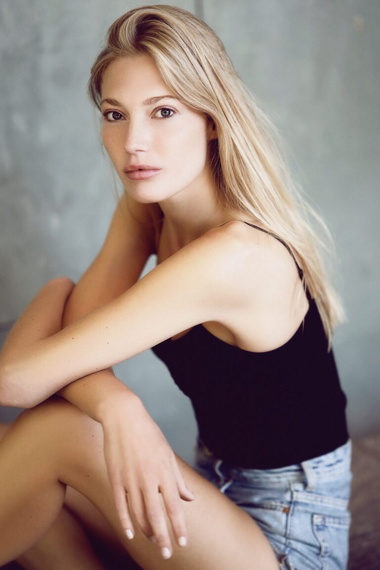 Sedcard-Foto: Model sitzend vor grauem Studiohintergrund