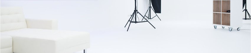 Weißes Studio mit Couch, Lichtstativen und Softboxen